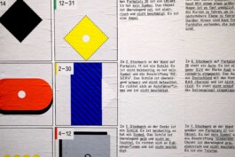 Detailansicht von Symbolen und Texten, die an eine Wand gekleistert wurden.